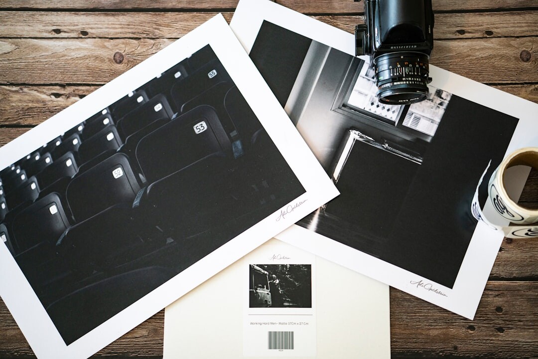 Printed documentary photographs and contact sheets laid out on a wooden table
